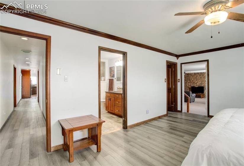 Bedroom featuring a closet, light wood-type flooring, ceiling fan, and connected bathroom