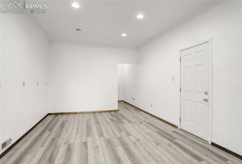 Empty room featuring light hardwood / wood-style flooring and crown molding
