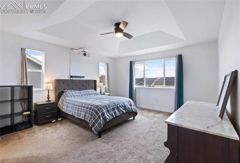Upstairs primary bedroom with coffered ceiling and great natural light