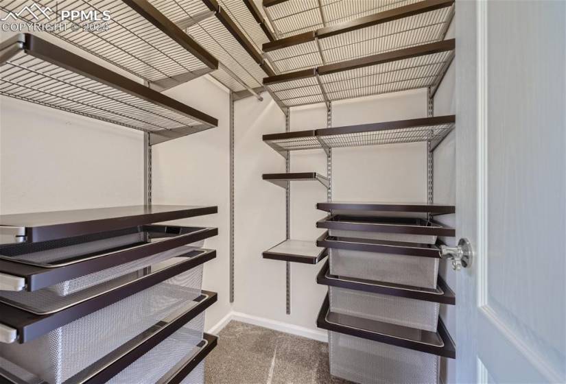 Spacious closet featuring custom shelves