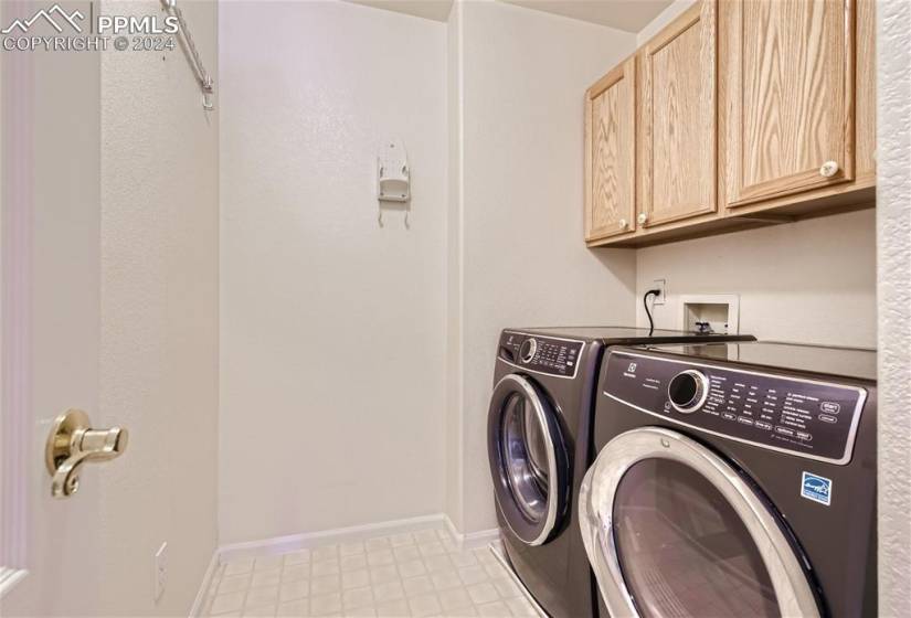 Laundry room located on the upper level  washer and dryer, with storage