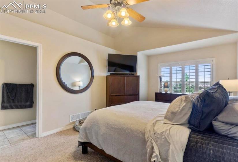 Bedroom featuring carpet flooring, ceiling fan, and vaulted ceiling
