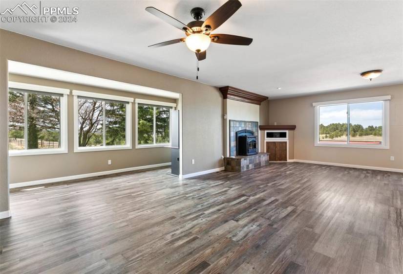 Unfurnished living room featuring ceiling fan, hardwood / wood-style floors, and a fireplace