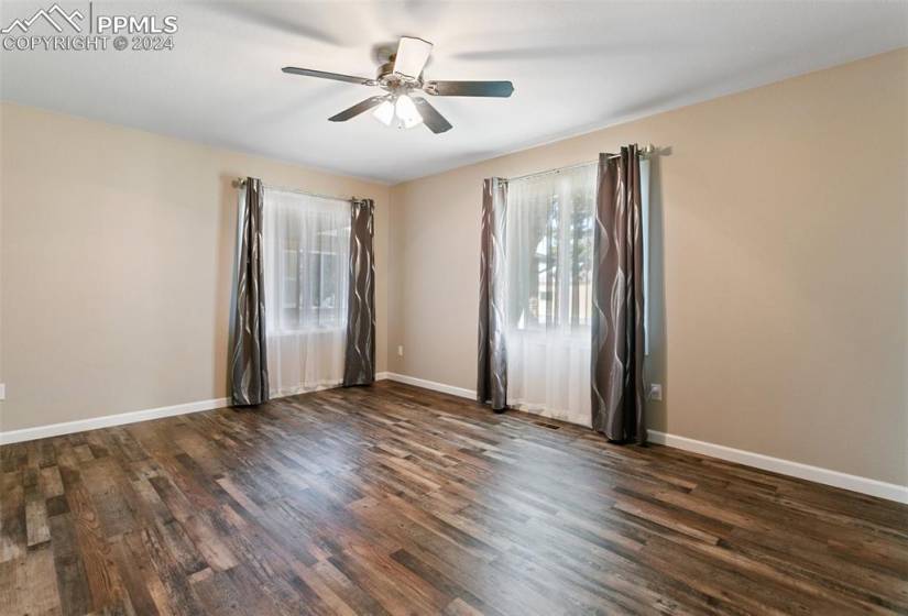 Unfurnished room with ceiling fan and dark hardwood / wood-style floors