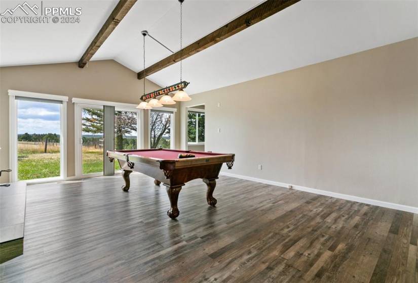Rec room featuring dark wood-type flooring, pool table, and vaulted ceiling with beams