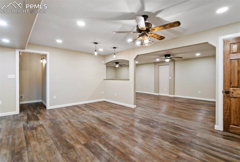 Unfurnished living room with dark hardwood / wood-style floors and ceiling fan