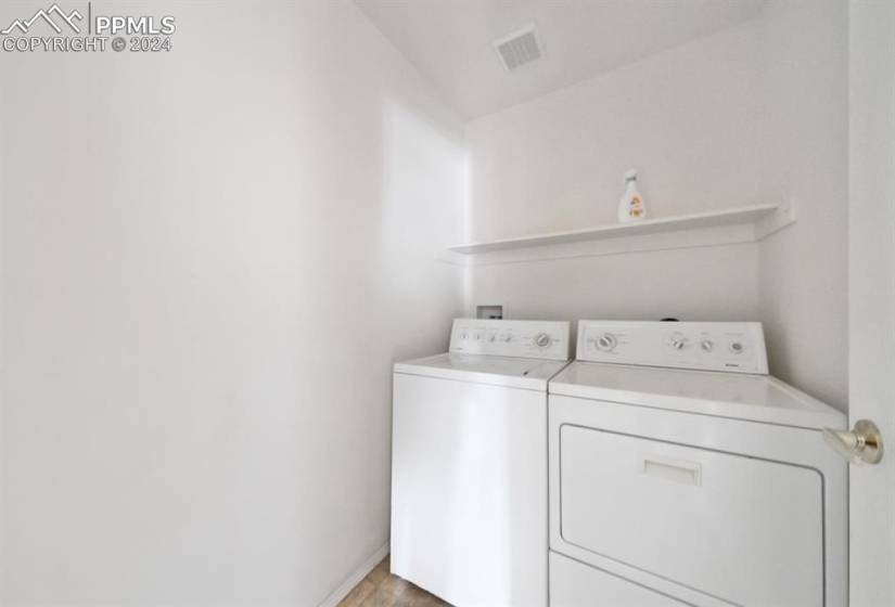 Laundry room with light hardwood / wood-style flooring and washer and clothes dryer