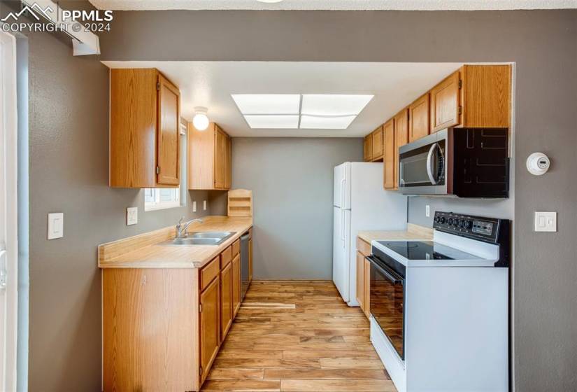 Kitchen featuring stainless steel appliances, sink, and light wood-type flooring