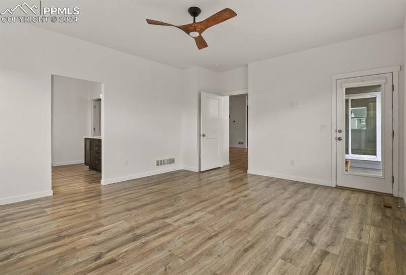 Main bedroom or home office with hardwood / wood-style floors and closet