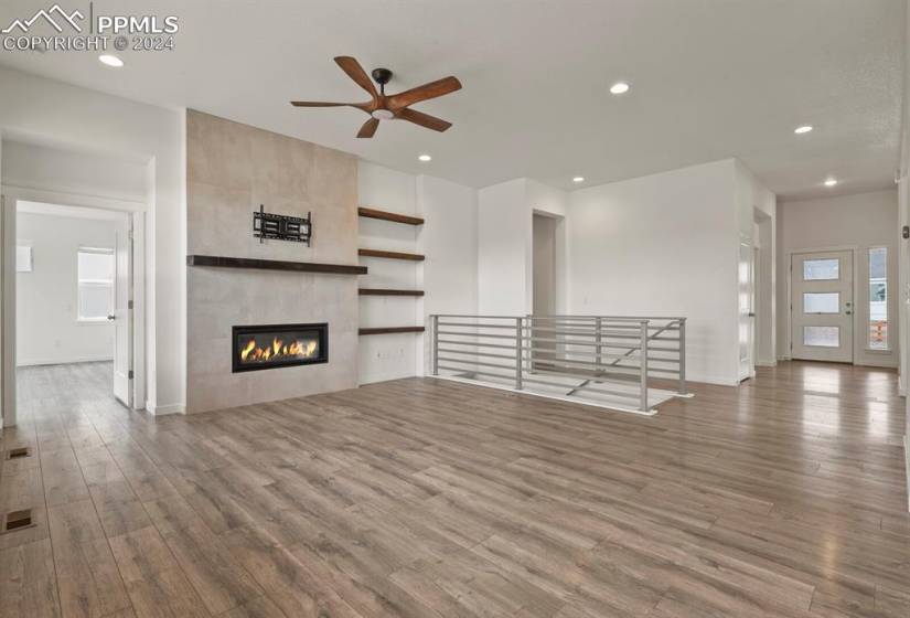 Great room featuring hardwood / wood-style floors, ceiling fan, and a tiled cosmo fireplace