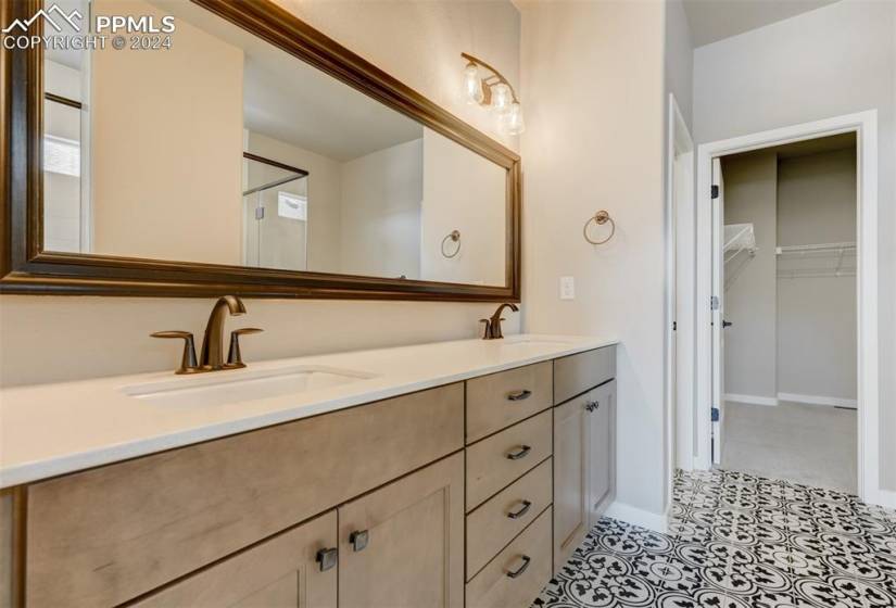 Bathroom with tile flooring, large vanity, and dual sinks