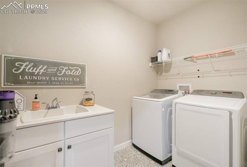 Laundry room featuring cabinets, sink, washing machine and dryer, and washer hookup