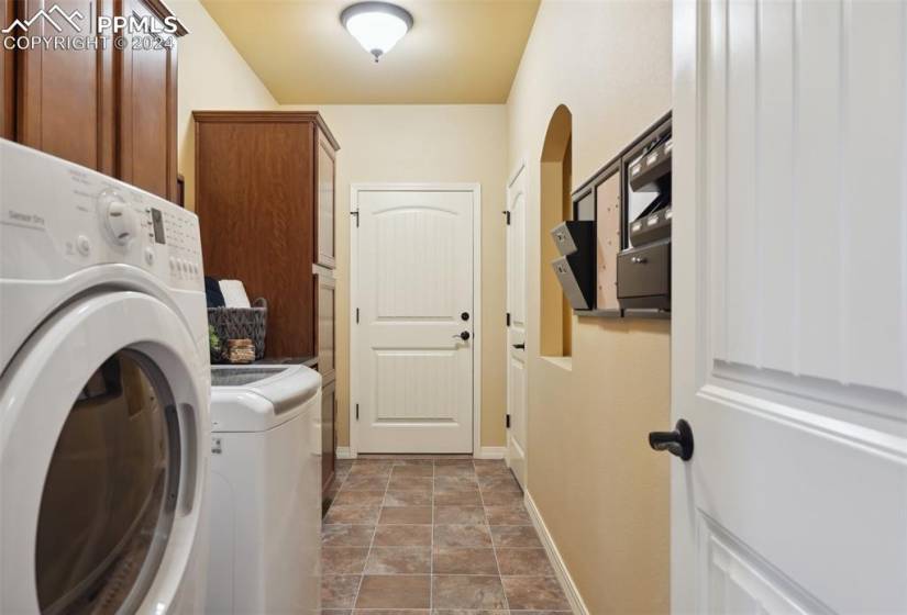 Laundry area featuring washing machine and clothes dryer, and cabinets