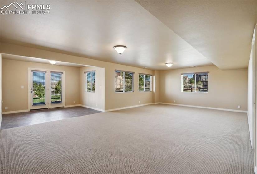 Walk-out basement family room featuring french doors and a healthy amount of sunlight