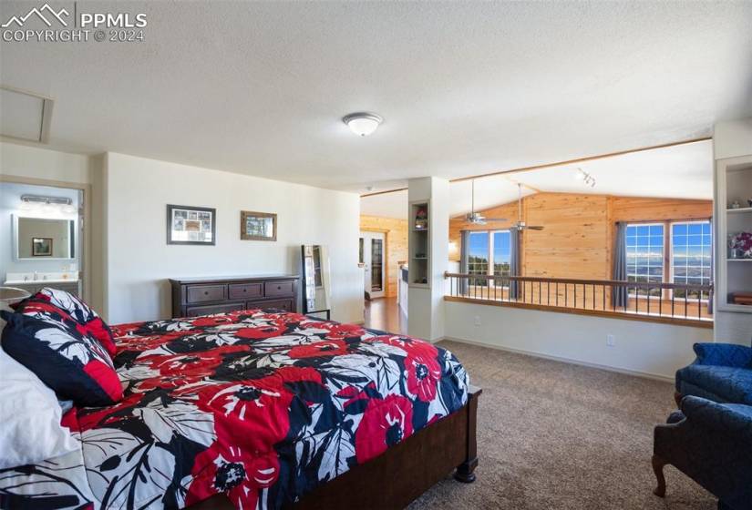 Primary suite on the upper level overlooking the living room with amazing mountain views