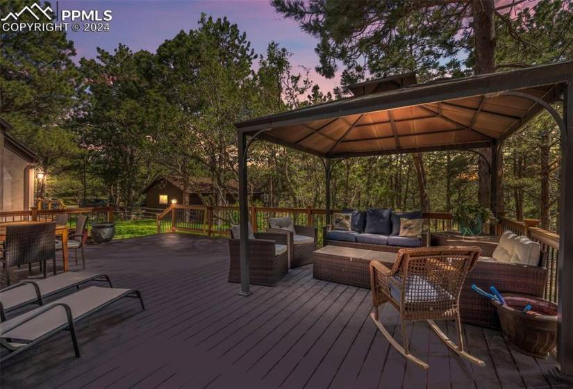 Deck at dusk with a gazebo and an outdoor hangout area