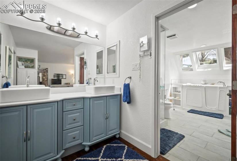 Bathroom with large vanity, tile floors, a bidet, and double sink