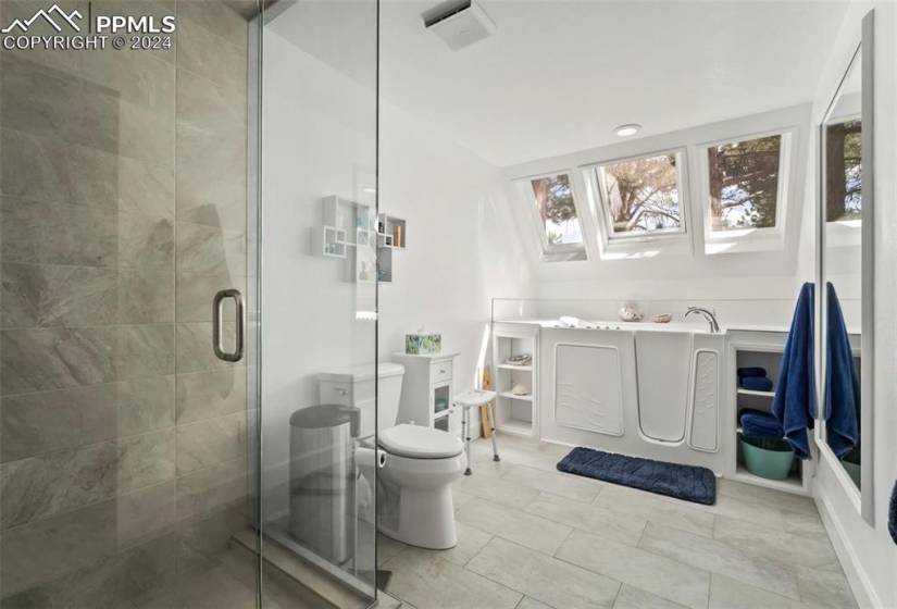 Bathroom featuring a skylight, toilet, and tile flooring