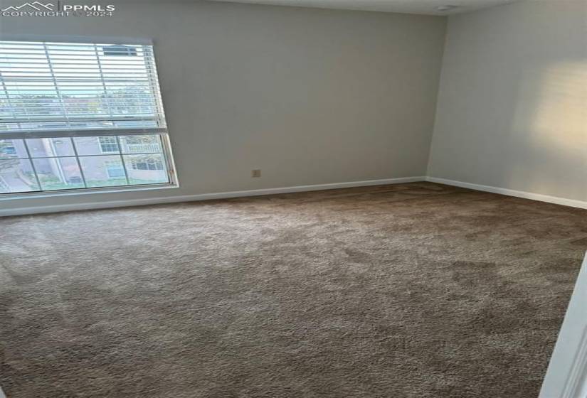 Empty room with a healthy amount of sunlight and carpet floors