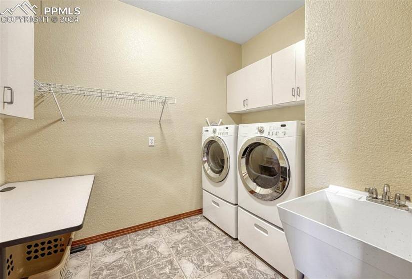 Laundry Room with sink, cabinets, and washer/dryer.