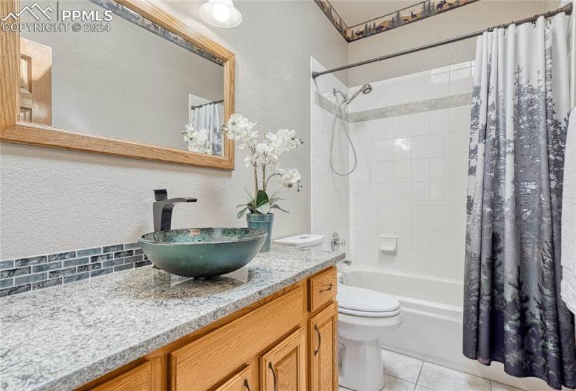 Remodeled Full Main-Level Bathroom with vessel sink, quartz vanities, and tiled tub/shower.