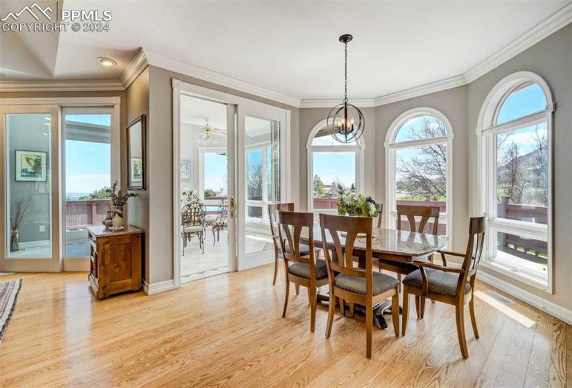 Dining space featuring a chandelier, crown molding, and light hardwood / wood-flooring