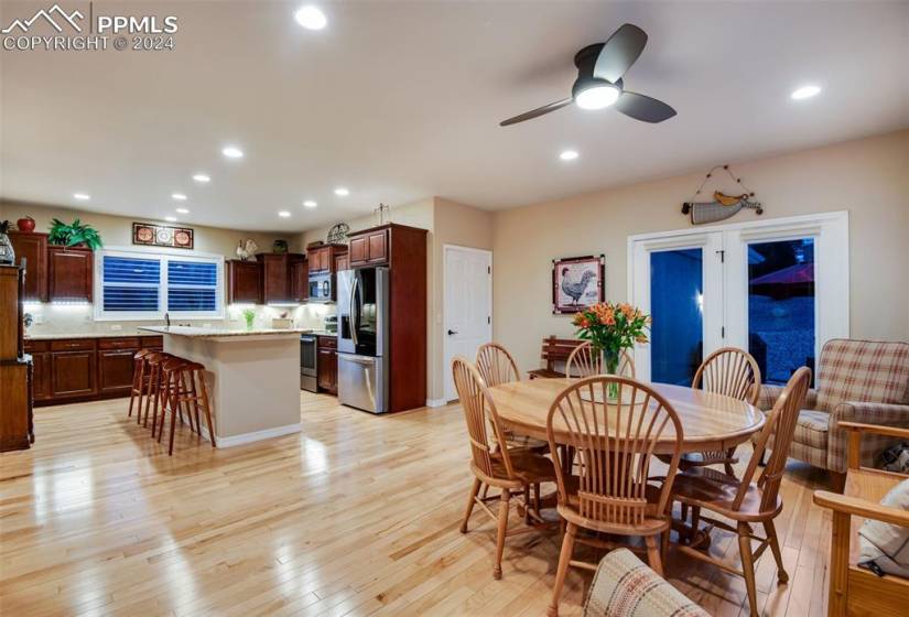 Dining space with ceiling fan and light hardwood / wood-style flooring