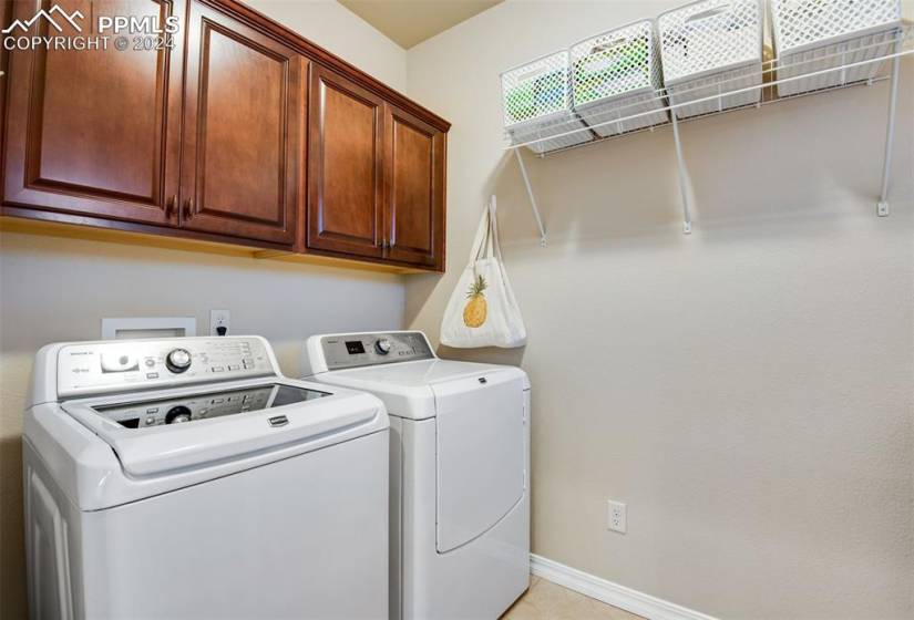 Laundry area featuring cabinets and washing machine and clothes dryer