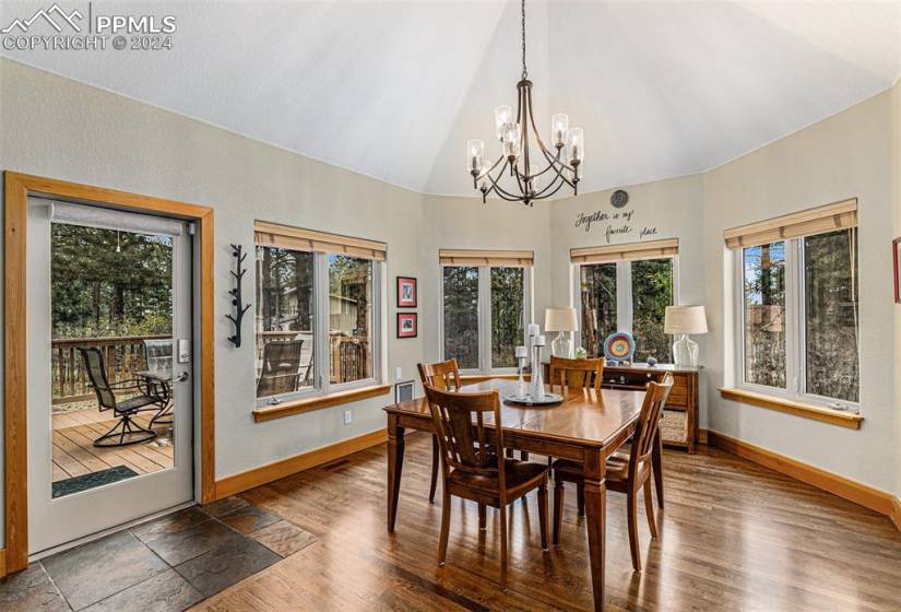 Dining room featuring high vaulted ceiling, hardwood / wood-style flooring, and a chandelier