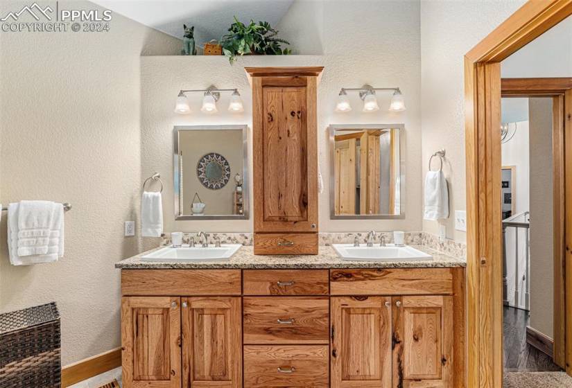 Bathroom featuring hardwood / wood-style flooring, lofted ceiling, and double sink vanity