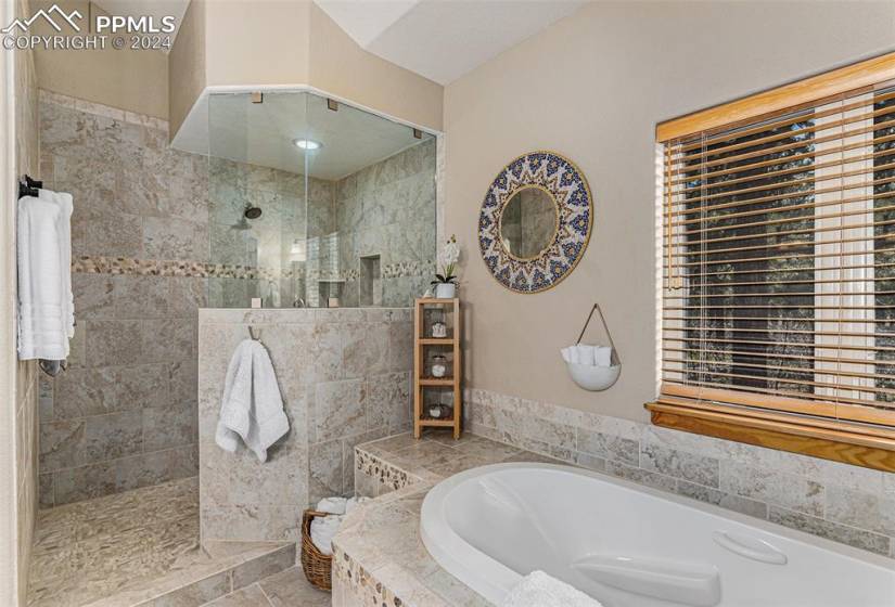 Bathroom with tile flooring, shower with separate bathtub, and vaulted ceiling