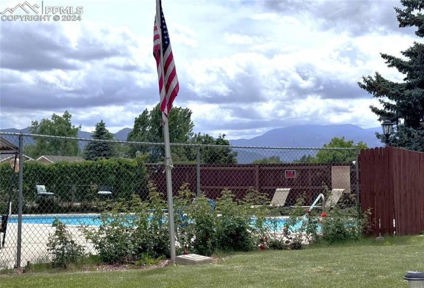 View of swimming pool with a mountain view and a yard