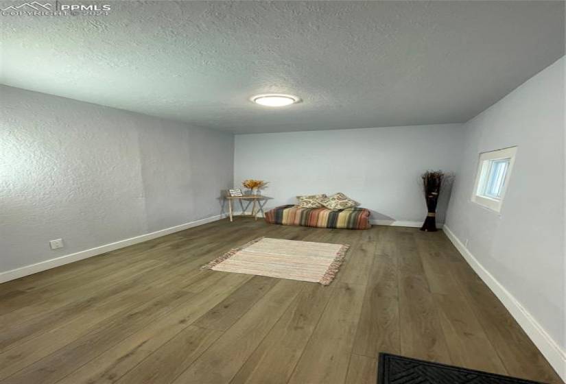 Unfurnished bedroom featuring a textured ceiling and wood-type flooring