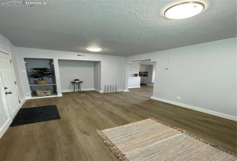 Unfurnished living room with hardwood / wood-style flooring and a textured ceiling