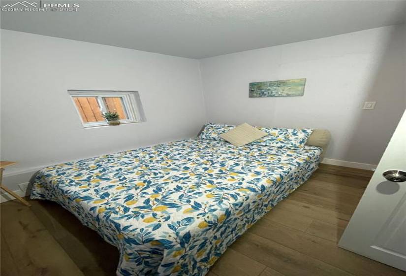 Bedroom featuring a textured ceiling and wood-type flooring