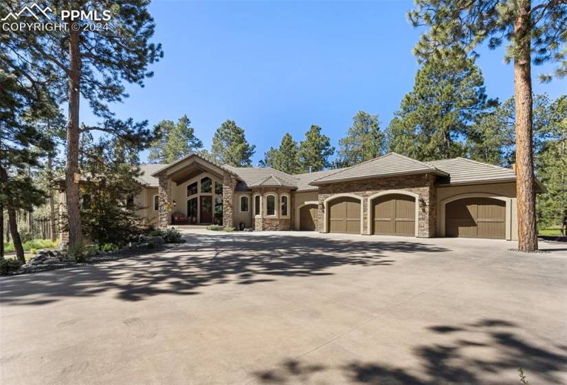 Front of home with 4 car garage, covered porch and entry to home.