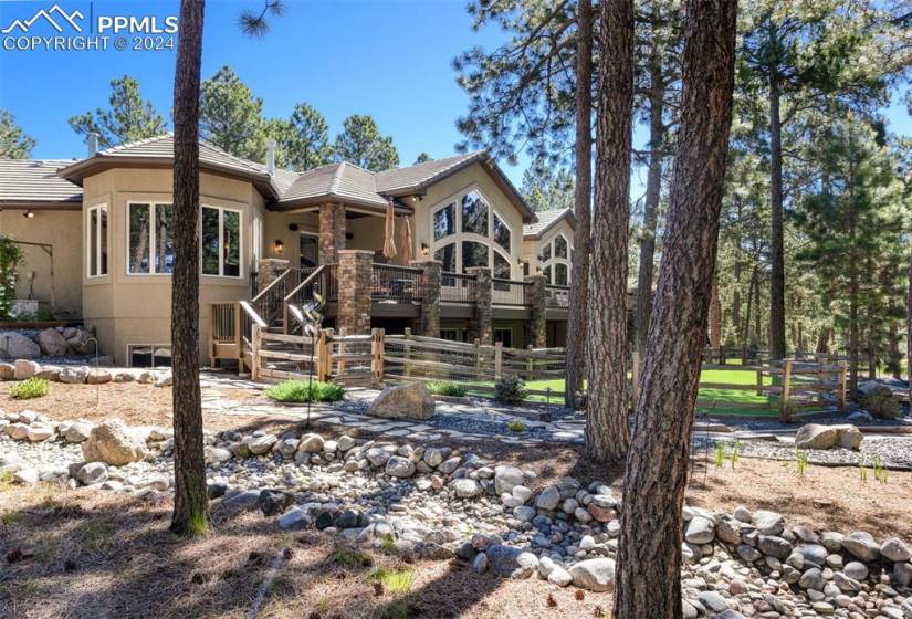 rear of home with beautiful landscaping