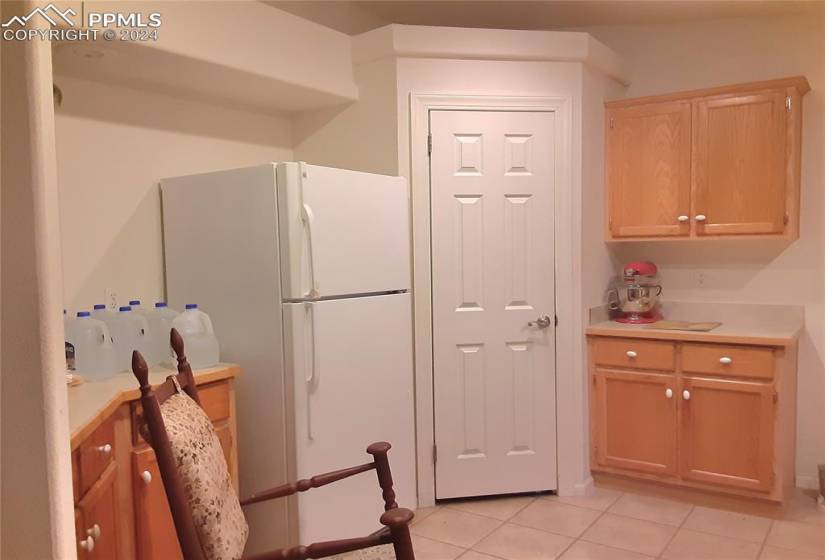Kitchen featuring white refrigerator, light tile floors, and light brown cabinets