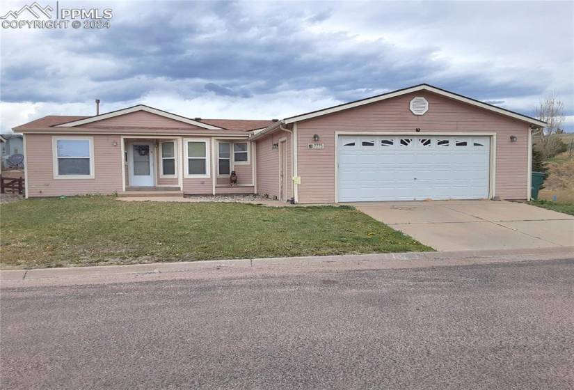 Ranch-style house with a front yard and a garage