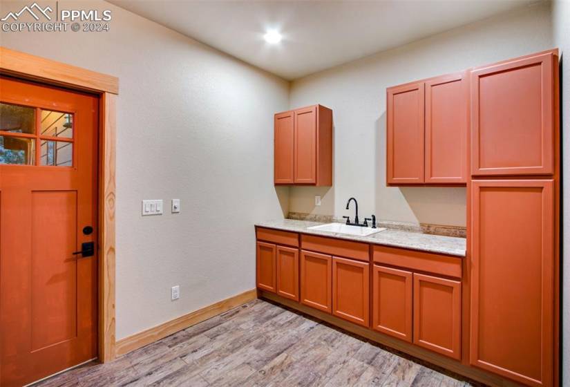 Kitchen featuring light hardwood / wood-style flooring, butcher block countertops, decorative light fixtures, track lighting, and light brown cabinets