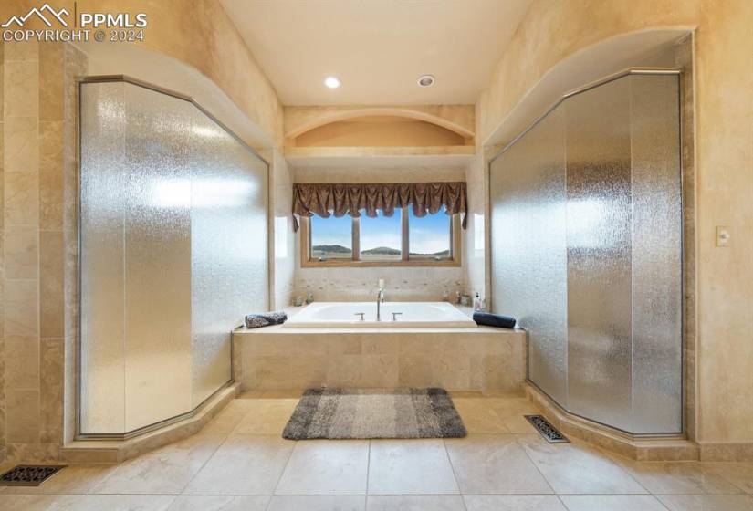 Bathroom with a wealth of natural light, a notable chandelier, vanity, and tile floors