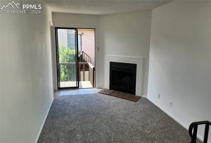 Unfurnished living room featuring carpet and a textured ceiling