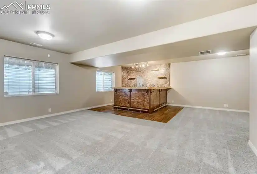 Basement featuring indoor bar and carpet floors