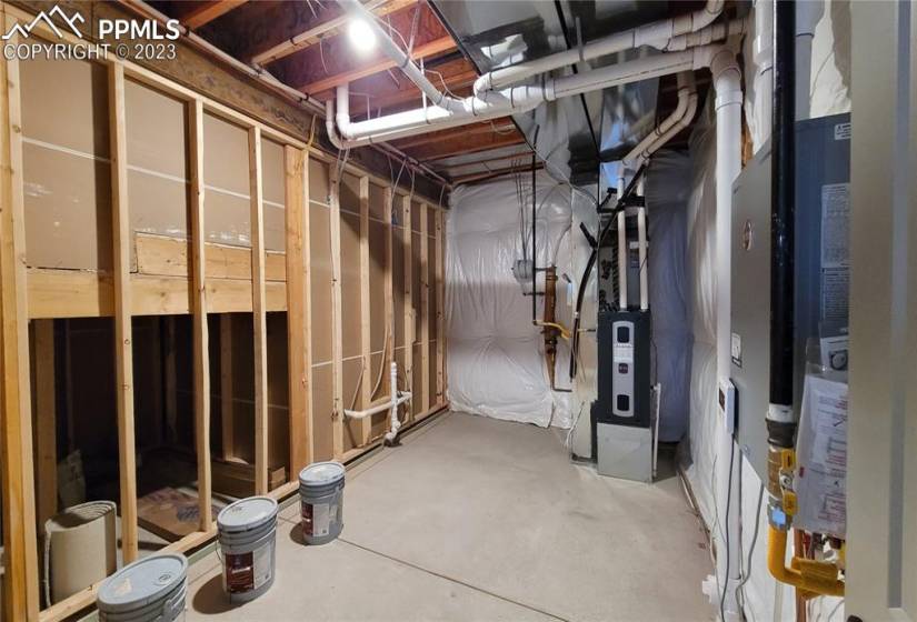 Storage/Utility room with a tankless water heater, 96% energy efficient furnace with a variable speed motor, pex water piping, sprinkler stub with vacuum breaker, and sealed ducts in this energy rated home!